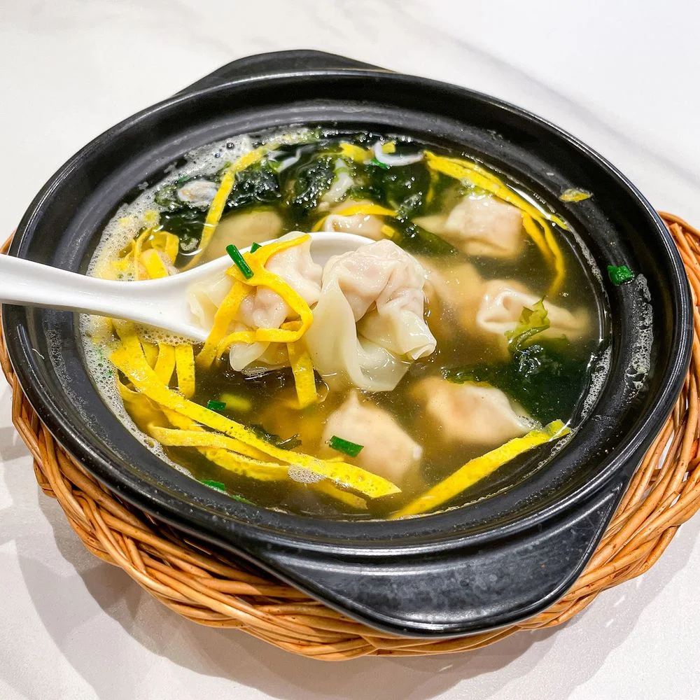 Hong Yu Fang: a bowl of soup with dumplings, greens and sliced garnish, pictured by the listed source
