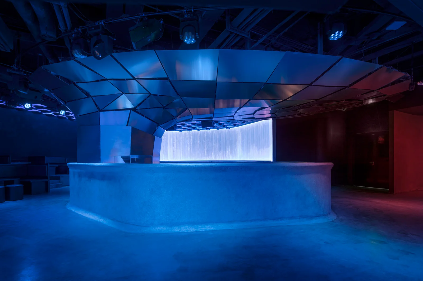 POTENT: blue lighting across the sculptural DJ booth and angular club ceiling