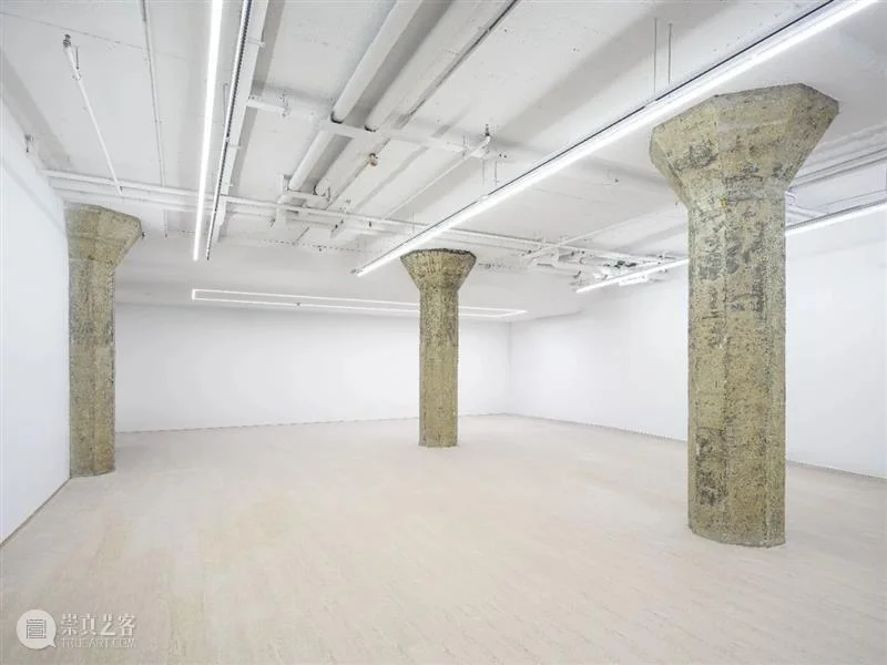 White gallery walls and exposed concrete columns at ShanghART SUHE, Shanghai