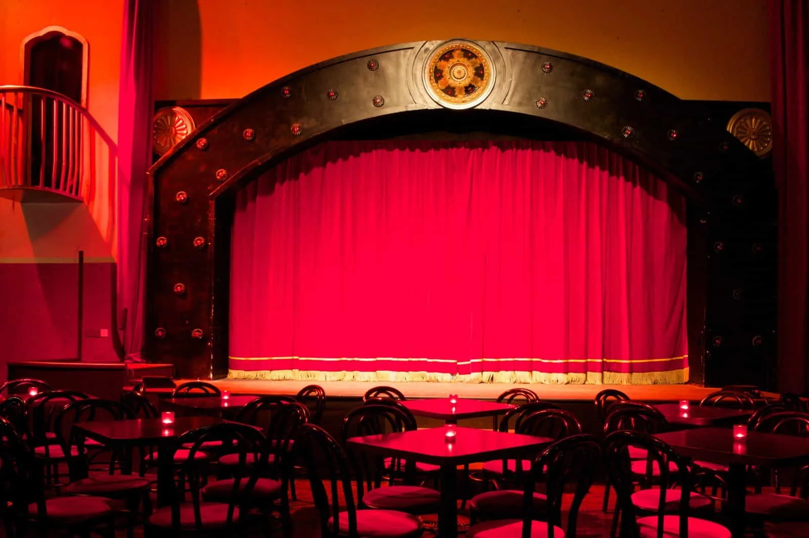 The red-curtained stage and cabaret tables at The Pearl