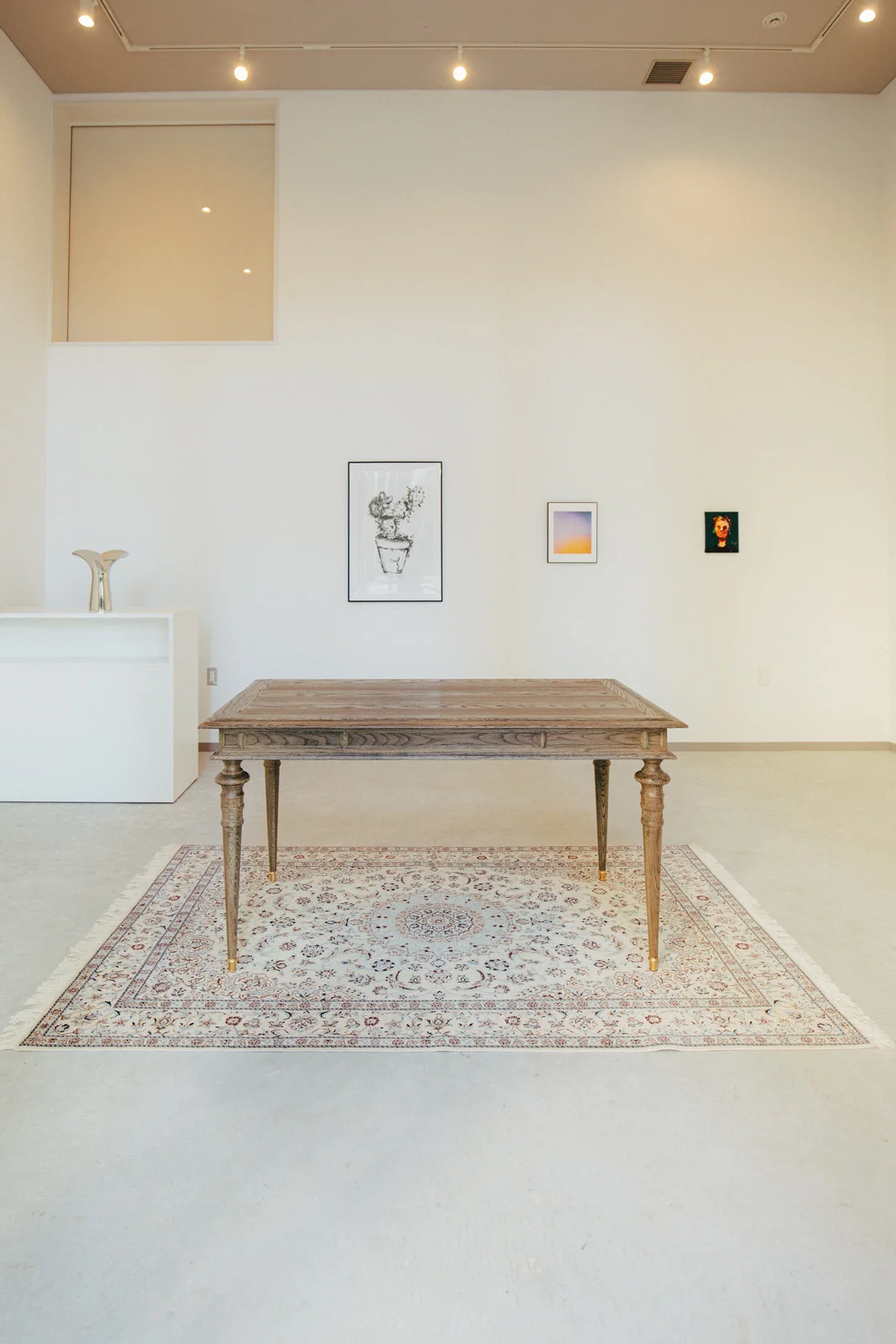 Everandart: the bright exhibition space with artworks and a central display table