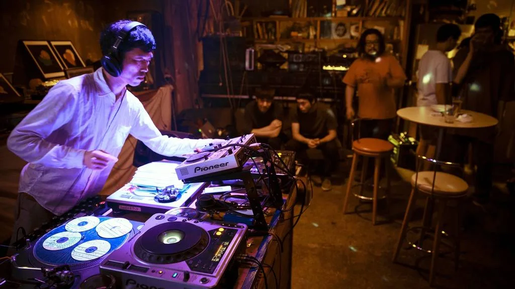 FORESTLIMIT: a DJ at the mixing desk in the intimate music venue