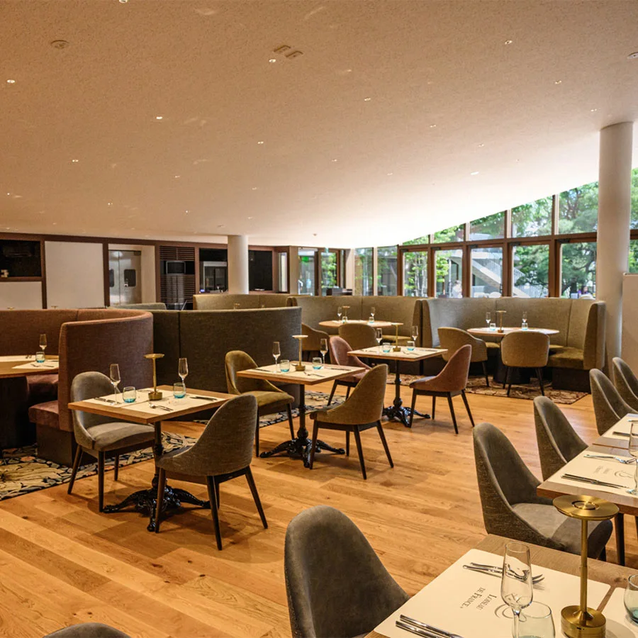 A sunlit dining room with pale wooden furniture at Loiseau de France