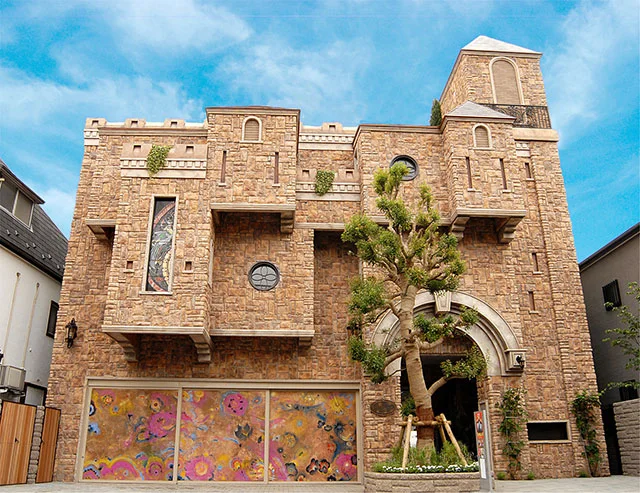 The Artcomplex Center of Tokyo: the distinctive stone-and-mosaic gallery facade beneath a blue sky