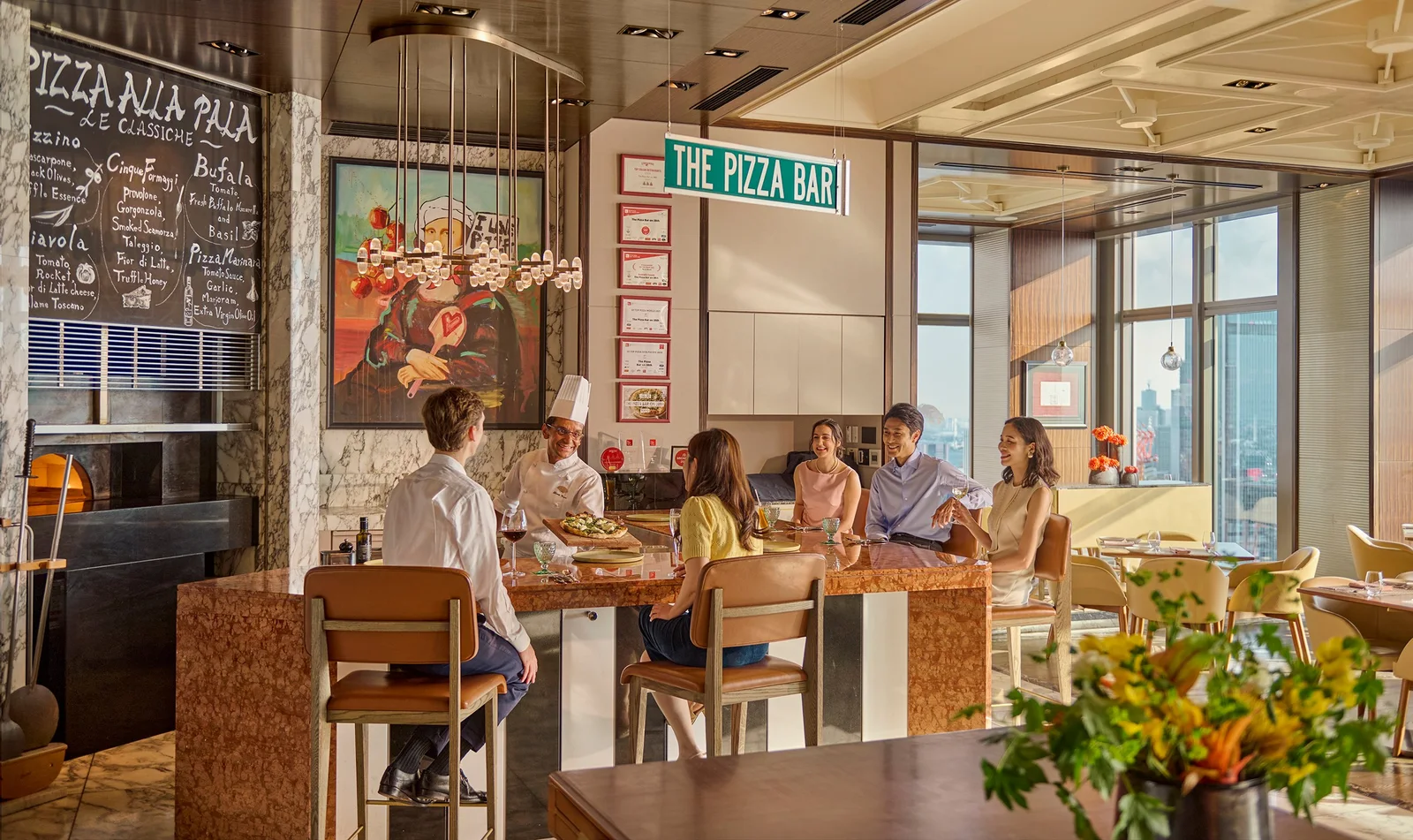 Guests seated at the pizza counter at The Pizza Bar on 38th