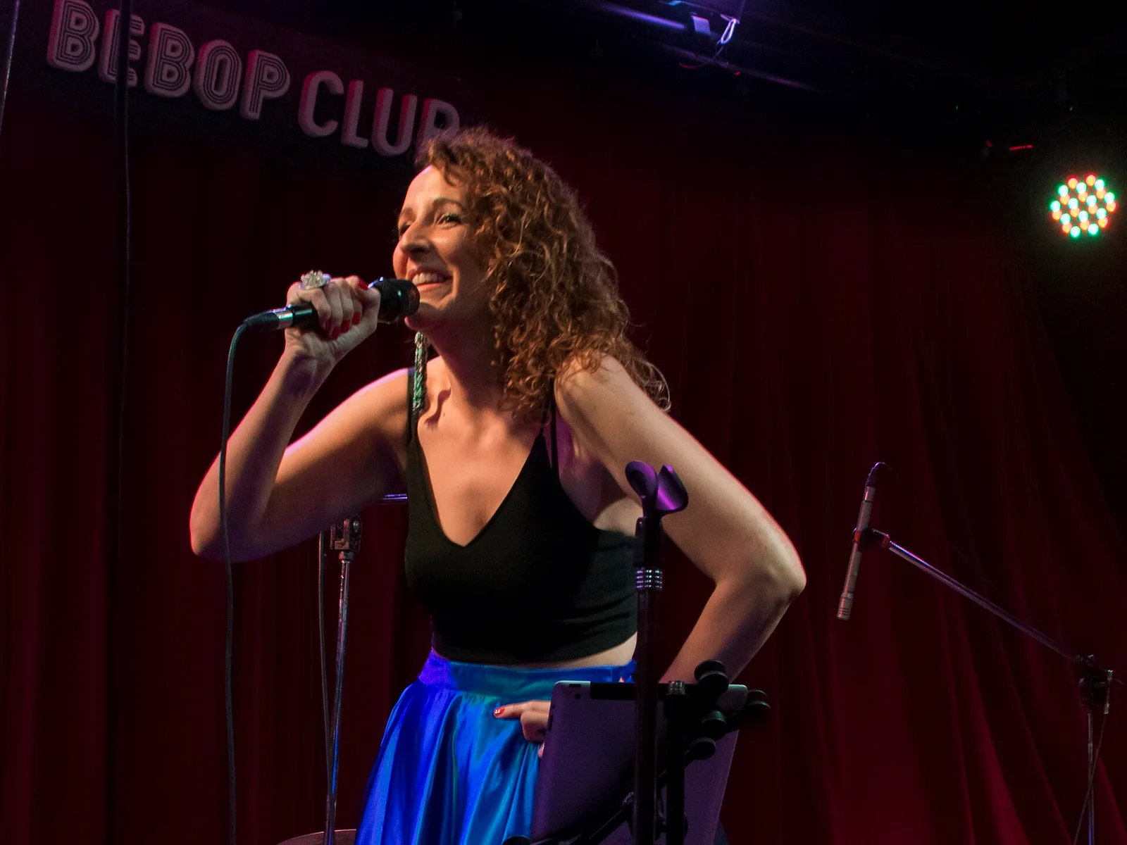 Ceci Méndez performing on the red-curtained stage at Bebop Club in Buenos Aires in October 2023